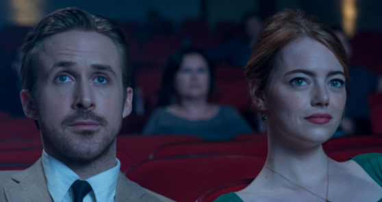 Ryan Gosling/Sebastian (left) and Emma Stone/Mia sitting in a movie theater. Photo by Dale Robinette. 
