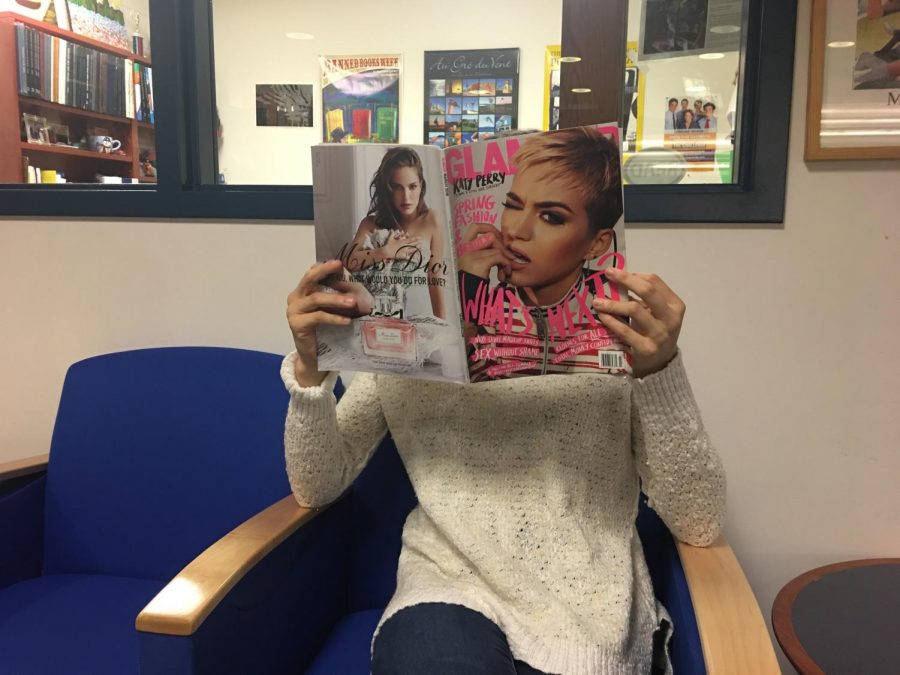 Senior Erin B. reads a magazine about celebrities in the Media Center