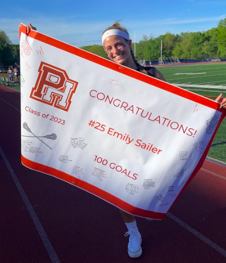 Sailer holding her 100th goal poster.