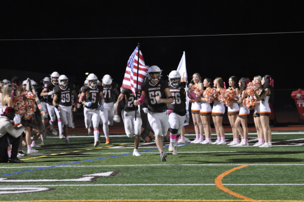 Senior Devon Buonanno carrying the American flag onto the field for the final time of the season.