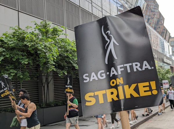 Actors and screenwriters holding signs during the strike.