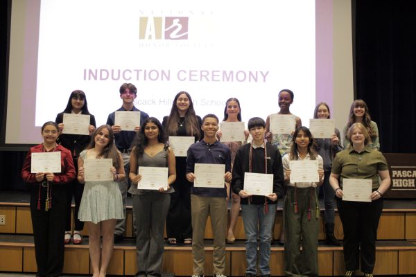 Inductees smiling with their certificates.